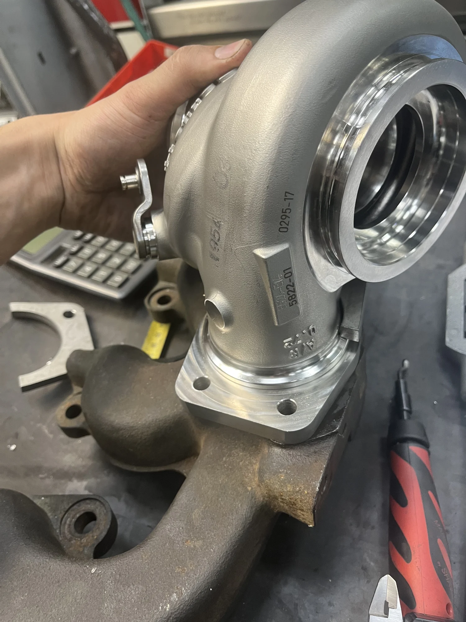 De flens gemonteerd op de turbo, in de hand gehouden