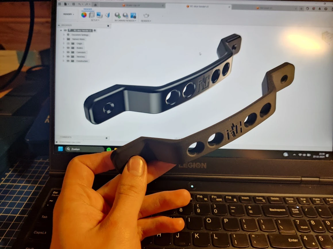 Een fysiek onderdeel naast het CAD-model op een beeldscherm