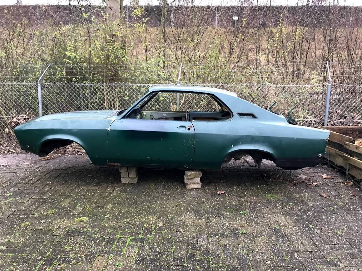 Carrosserie van de Opel A-Manta zonder wielen, buiten op steunen