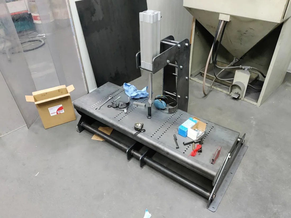 Een zelfgebouwde machine voor het demonteren van klepveren, met een pneumatische cilinder, in de werkplaats