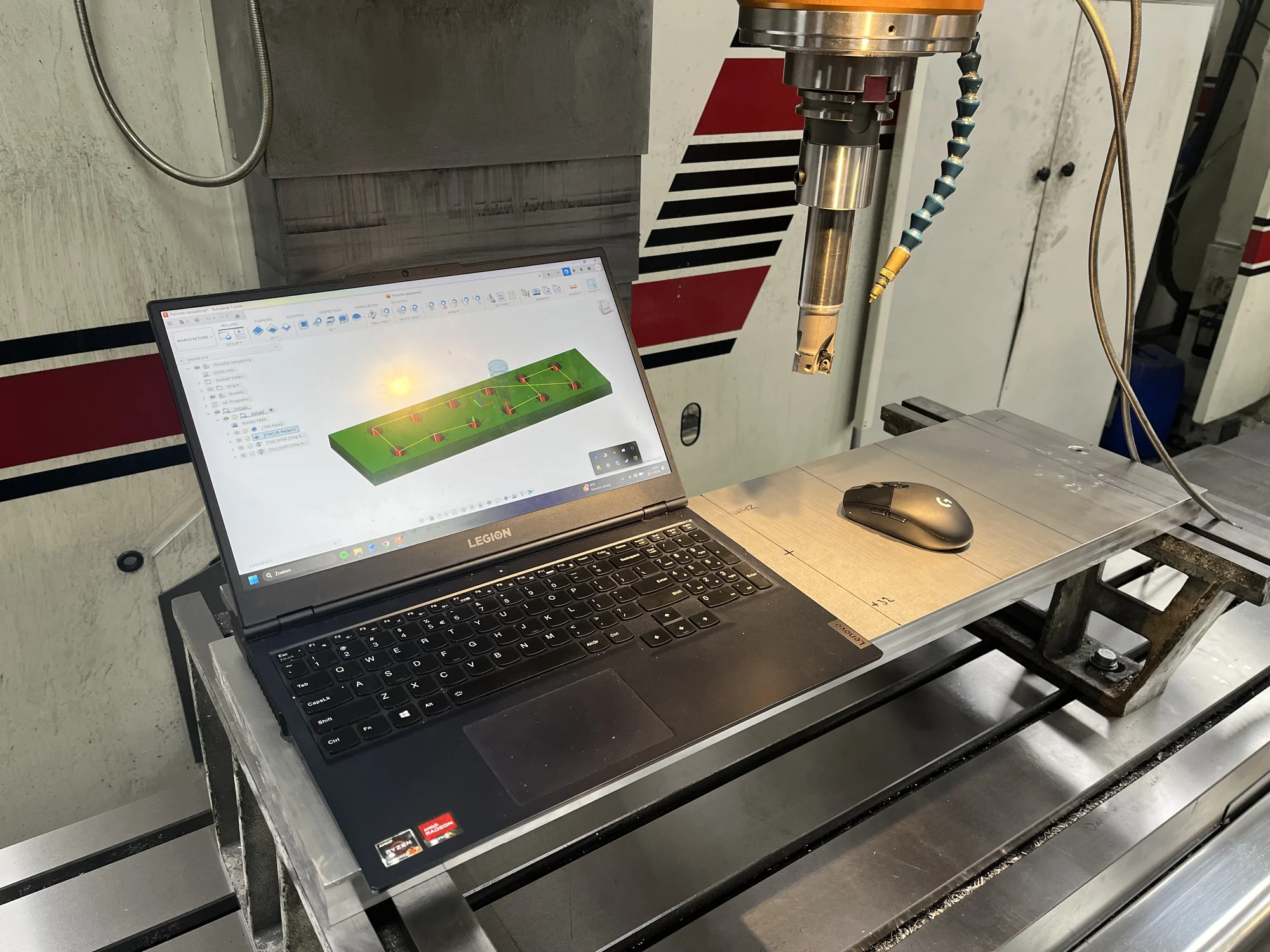 Een laptop met een freesprogramma naast de CNC-freesmachine in de werkplaats