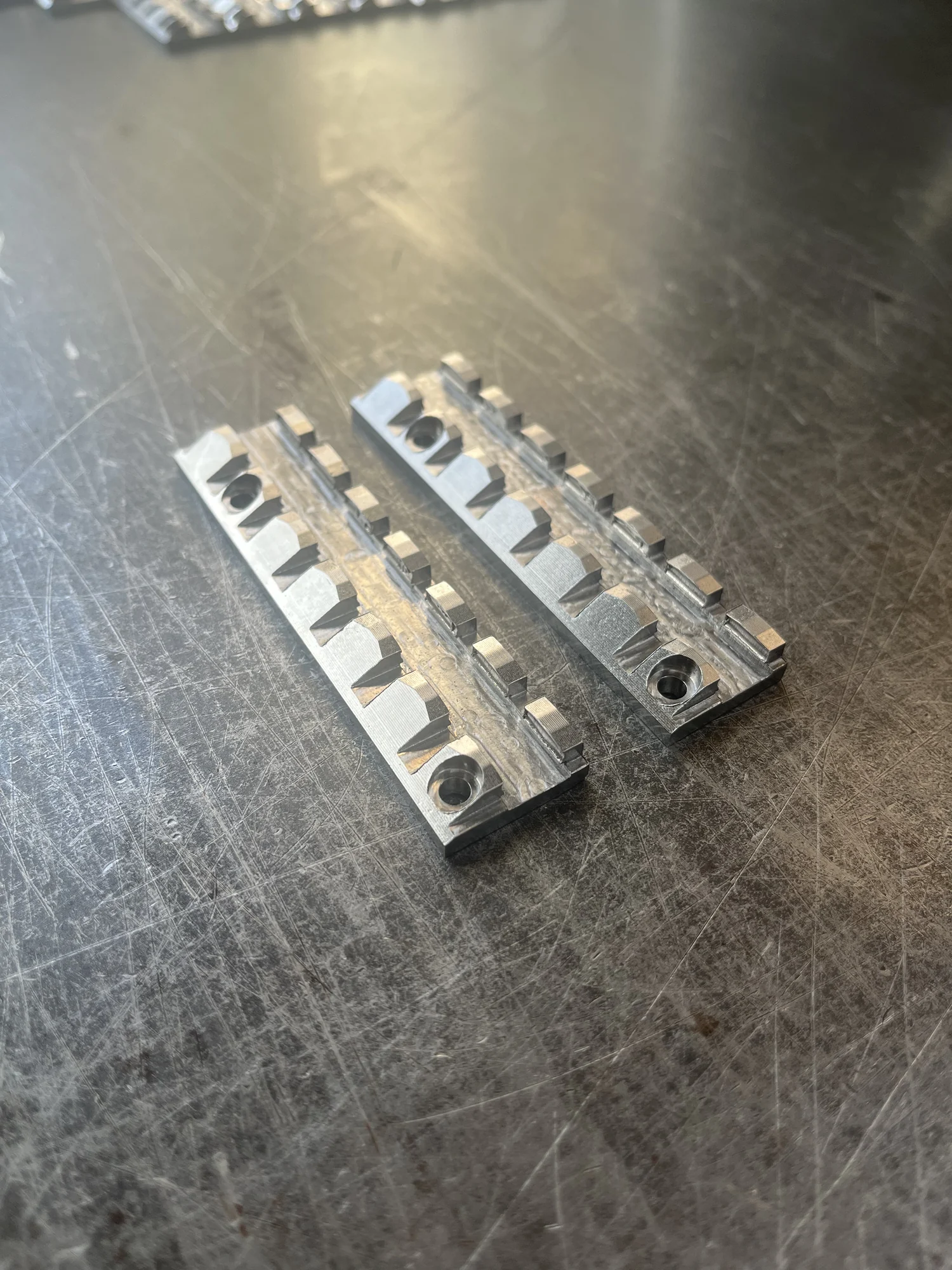 Twee gefreesde metalen hoonsteenhouders op een werkbank